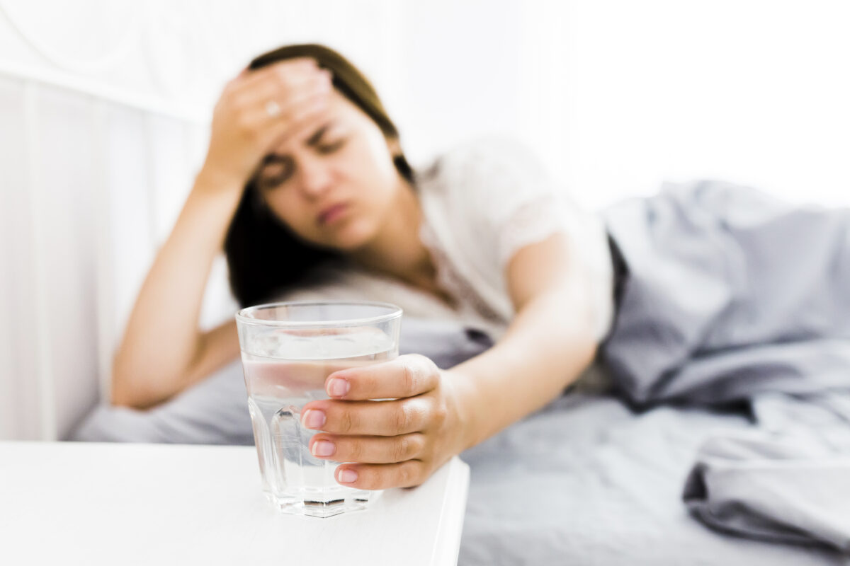 woman-with-headache-taking-glass-water-1200x800.jpg